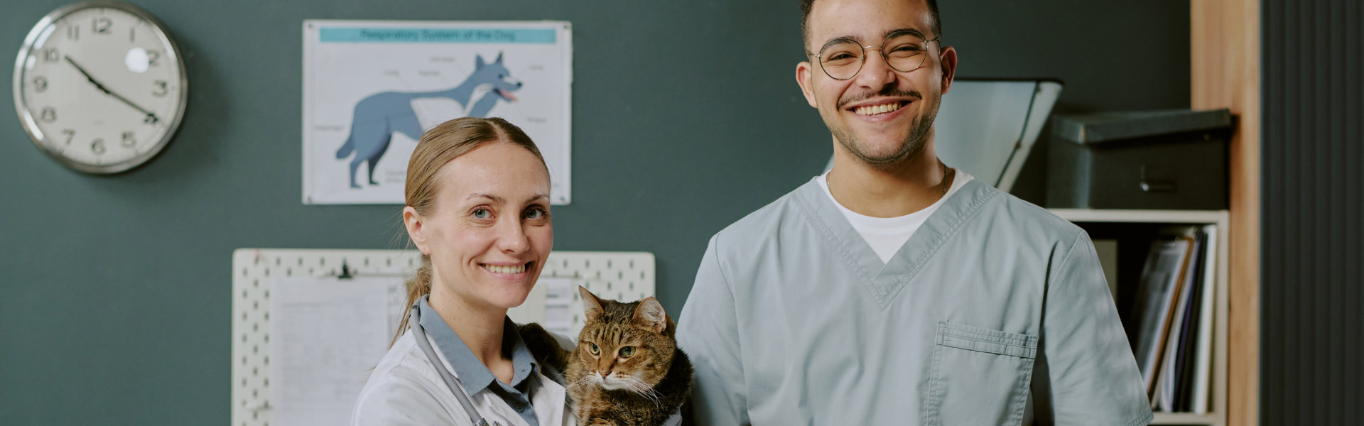 two person smiling and a cat